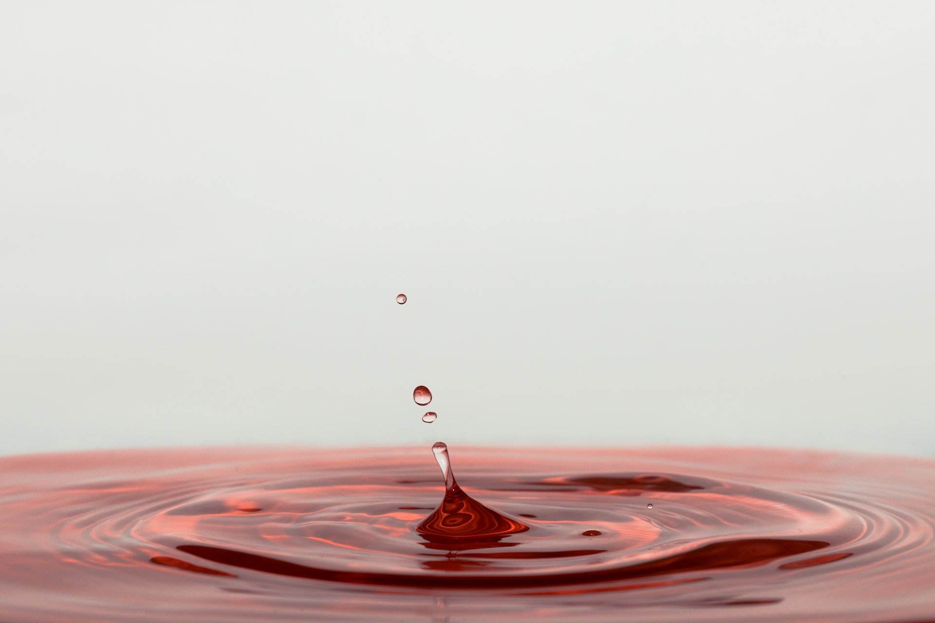 a drop of water falling into a brown liquid
